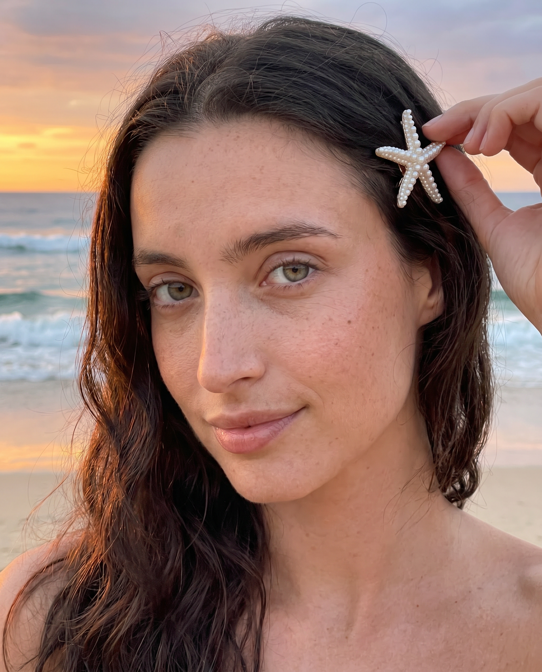 Model adjusting starfish hair clip at sunset